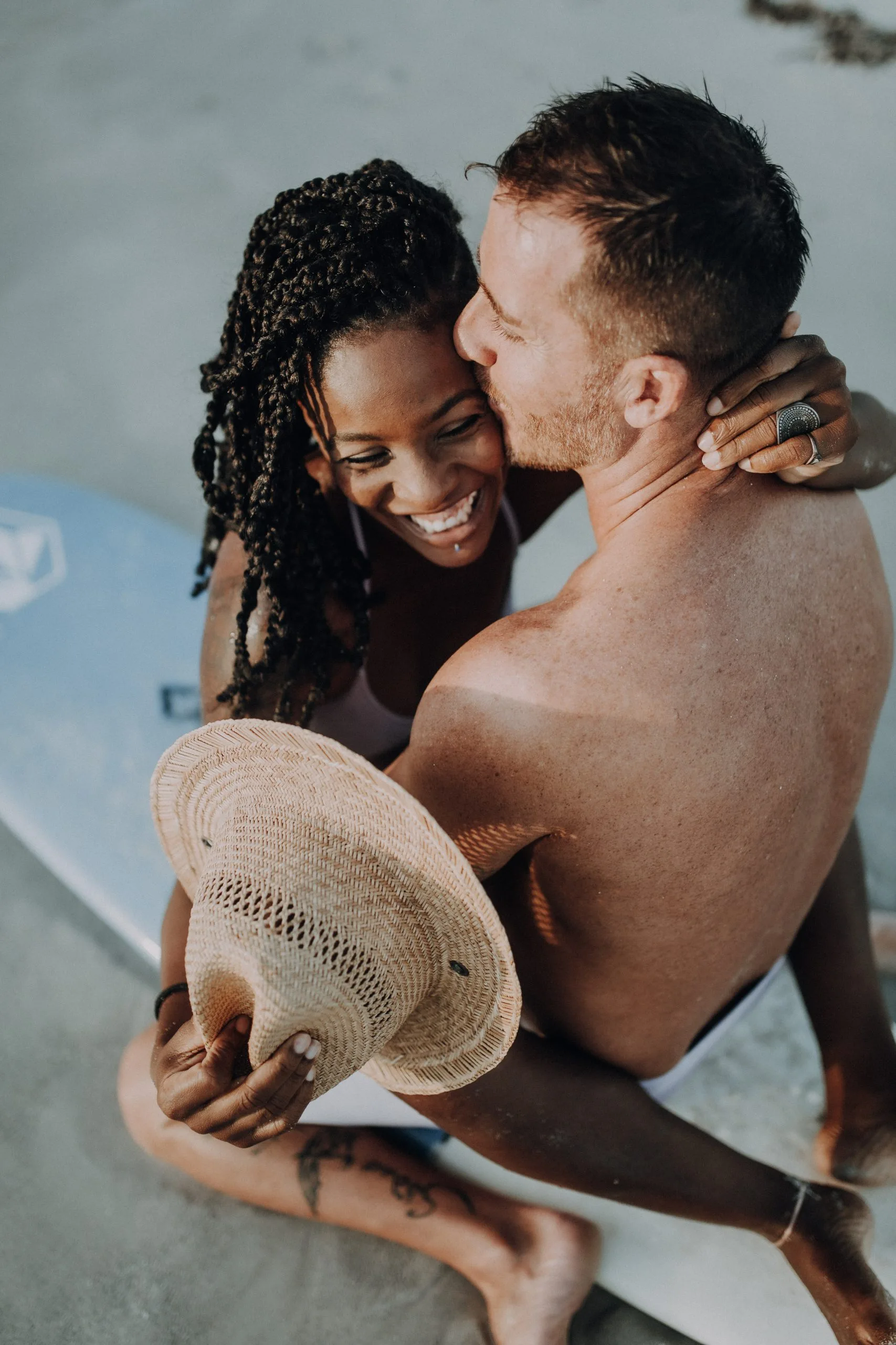 Portrait de couple dans l'eau en Guadeloupe – C & S 02 Femme souriante enlacée à son compagnon dans l'eau turquoise en Guadeloupe
