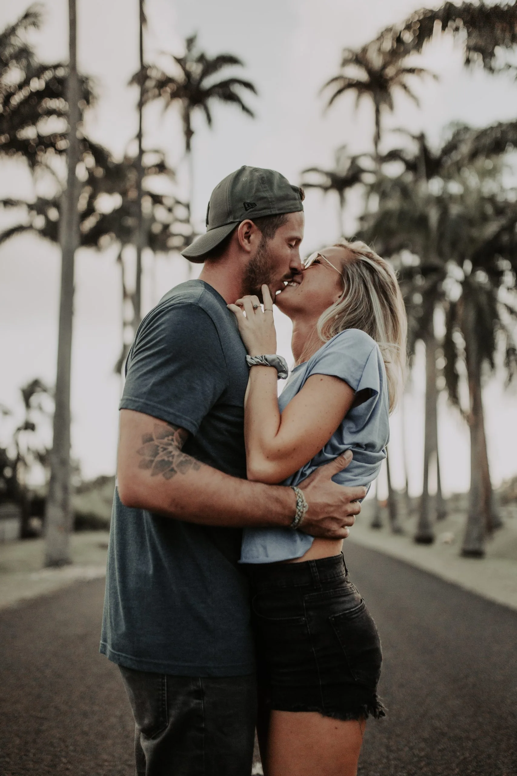 Couple s'embrassant en gros plan avec les palmiers de Guadeloupe en arrière-plan