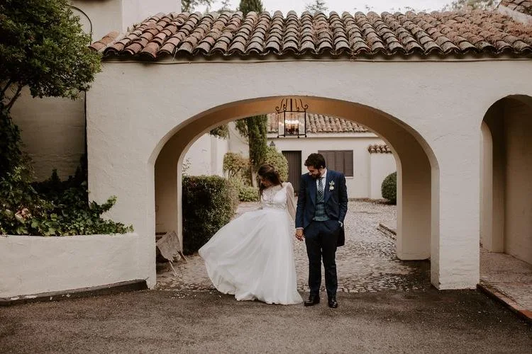 Architecture traditionnelle de style andalou du Cortijo de Mónico à Majadahonda avec un couple de jeunes mariés qui posent.
