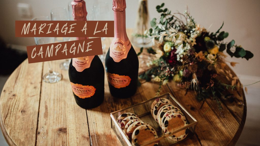 Affiche promotionnelle pour les séances photo de mariage à la campagne. On peut y voir des petits gâteaux, deux bouteilles de champagne rosé et un jolie petit bouquet de fleurs.