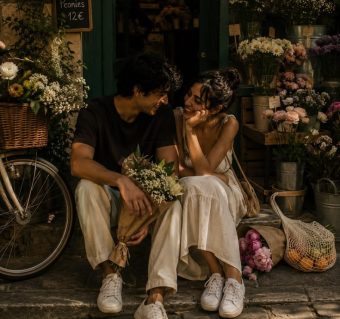 Couple entouré de bouquets de fleurs dans une boutique de fleuriste.