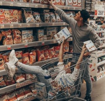 Couple s'amusant dans le rayon alimentaire d'un supermarché lors d'une séance photo décalée.