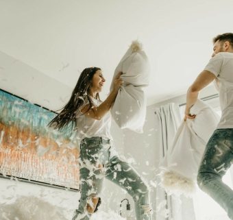 Couple jouant avec de grands draps blancs en extérieur lors d'une séance photo créative.