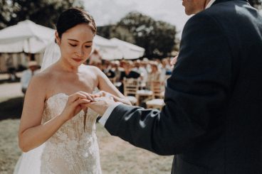 Portrait rapproché de la mariée pendant un moment d'échange des alliances avec son époux lors de la cérémonie.