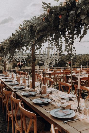 Tables de réception décorées avec des chandeliers et de la vaisselle dans le jardin du Château Lacoste.